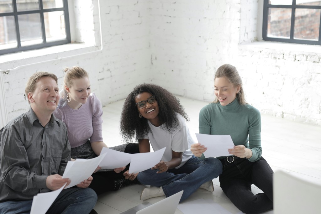 group of people sitting and looking at papers