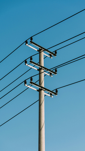 Eaton Fire News - Close-up of a telephone pole with multiple wires extending from the top, set against a clear sky.